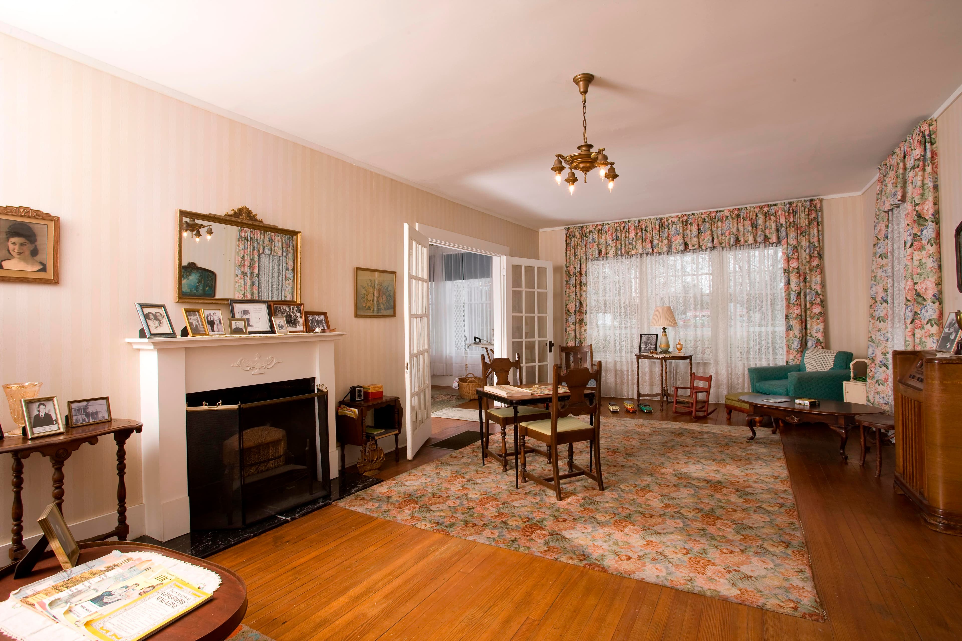 A view of the living room with a fireplace, rug, recliner and other furniture