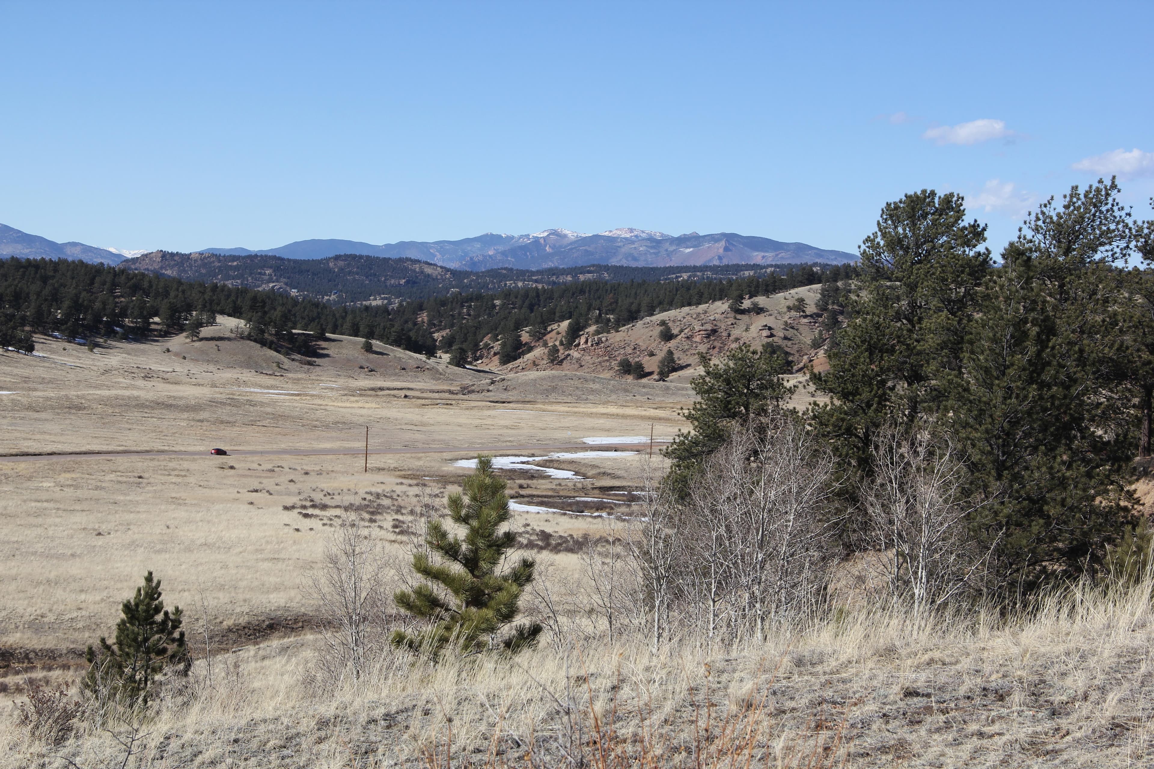 View of the Florissant valley with grassy meadows and mountains in the distance