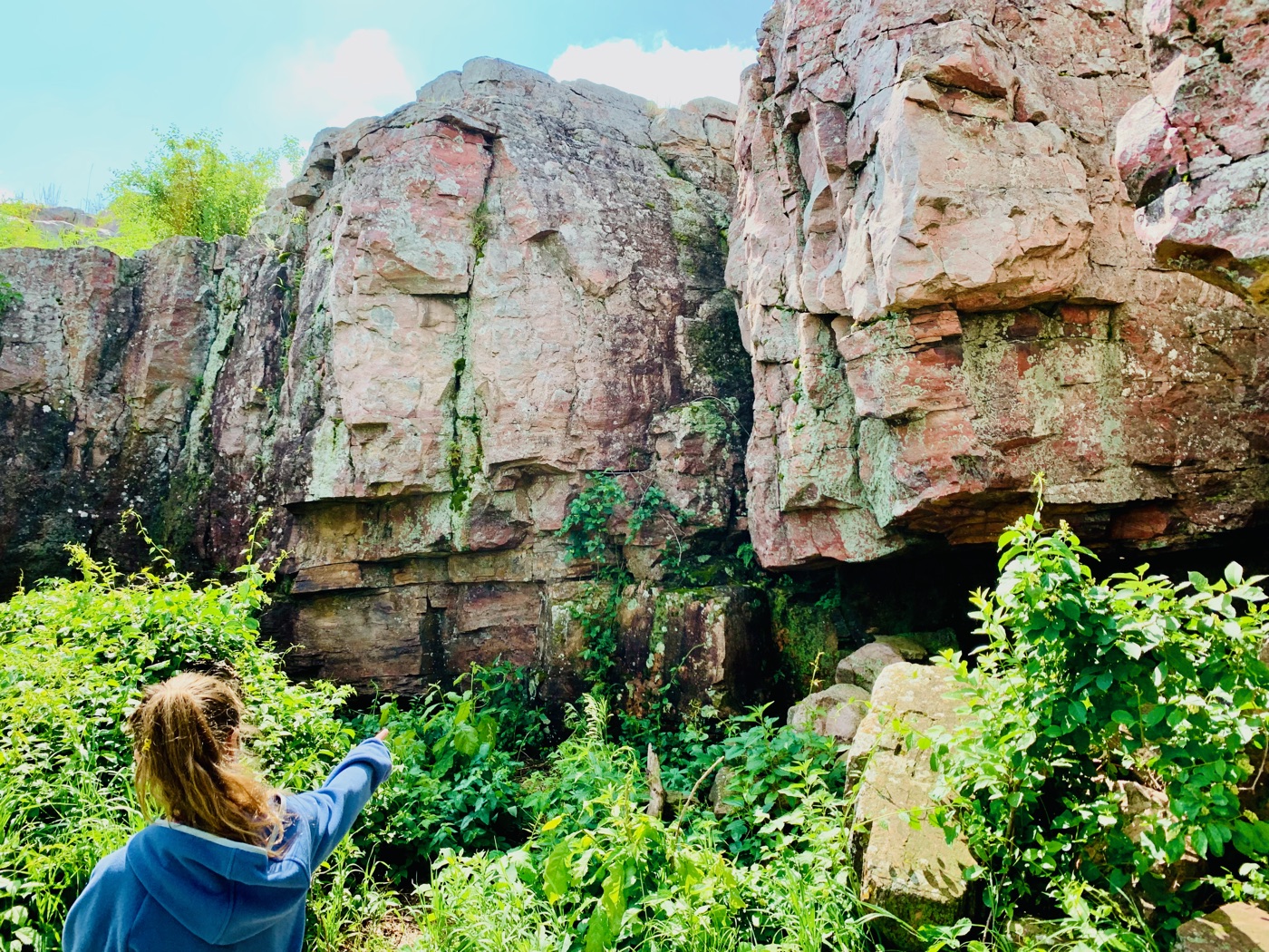 A daughter pointing up at the mysteries she found in the red rock wall