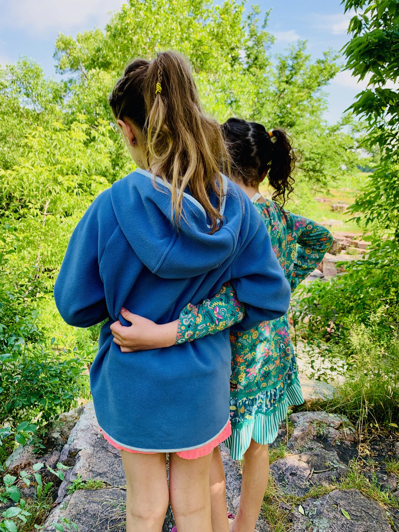 Two sisters, arm in arm, looking out over the old quarries