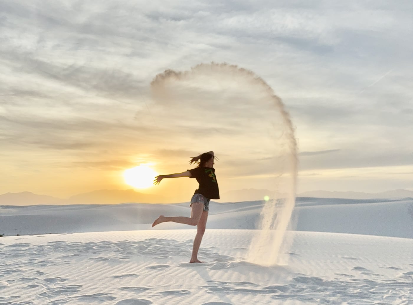 Phalen throwing sand in the sky, a perfect magic circle against the white dunes