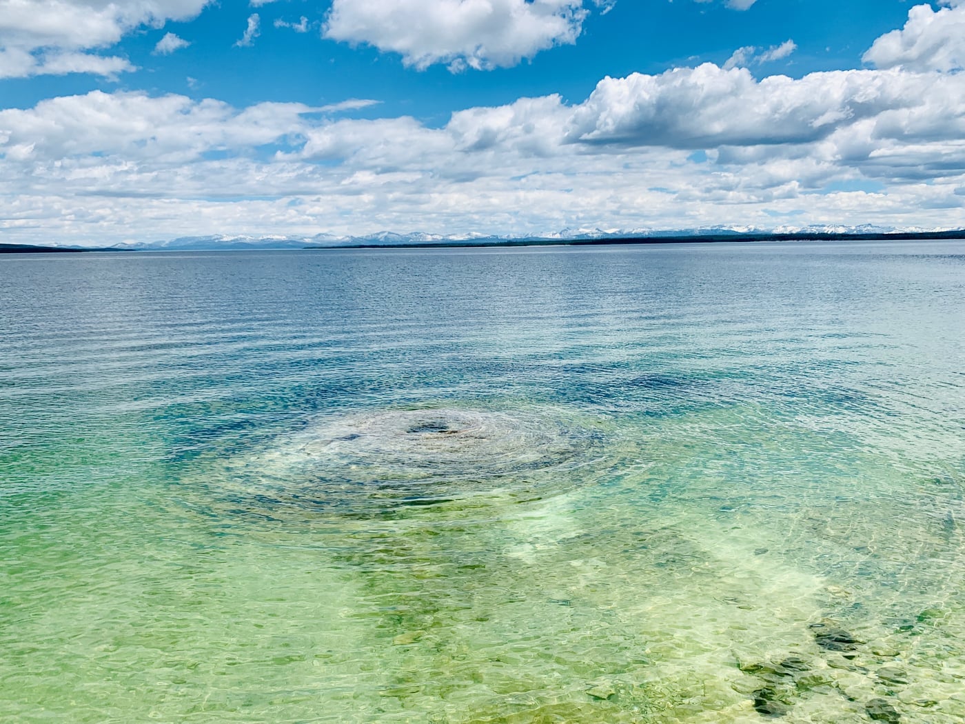 Yellowstone Lake, blue-green, the Absaroka Range standing behind it