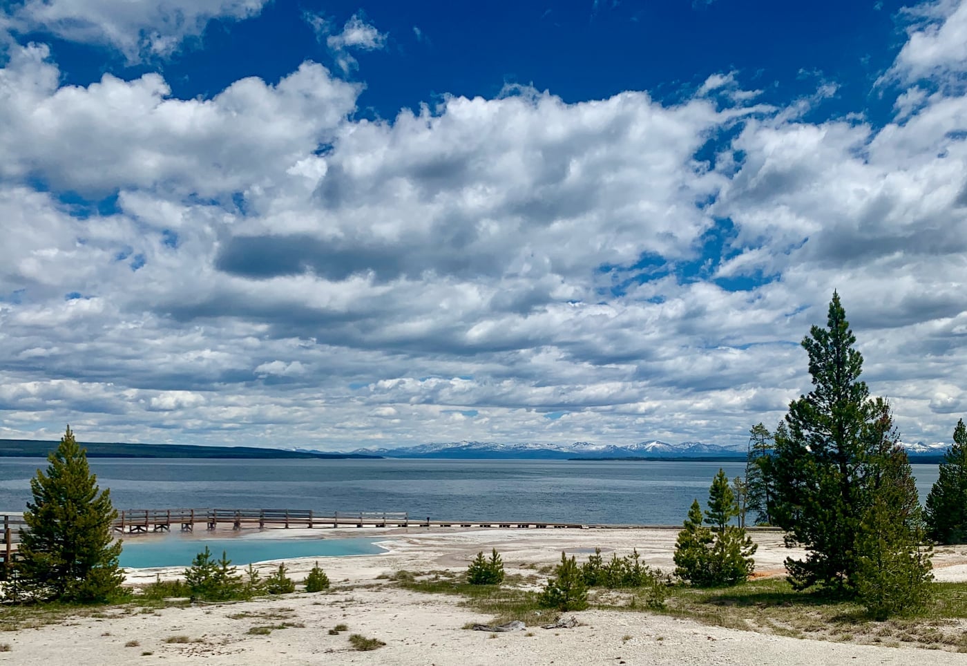 A pool by the lake under blue skies and white clouds