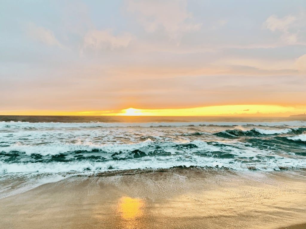 Heart Reflected in the Ocean with a brilliant magnetic sunset and dancing ocean waves in the background
